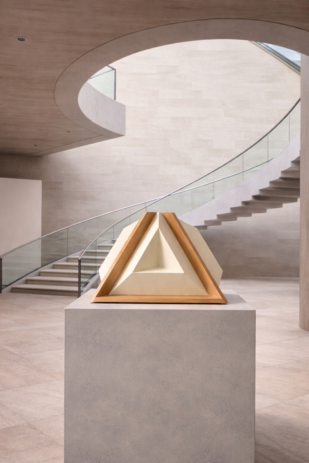The loudspeaker on a plinth beneath a spiral stair